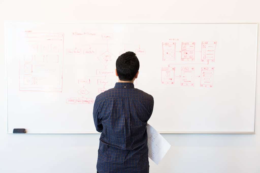Homme analysant un diagramme sur tableau pour représenter l'analyse d'une automatisation